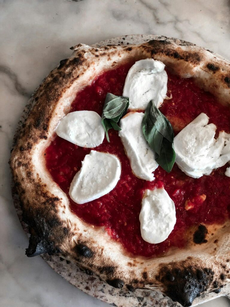 Delicious Margherita pizza with fresh basil, melted cheese, and tomato sauce on a crispy crust.