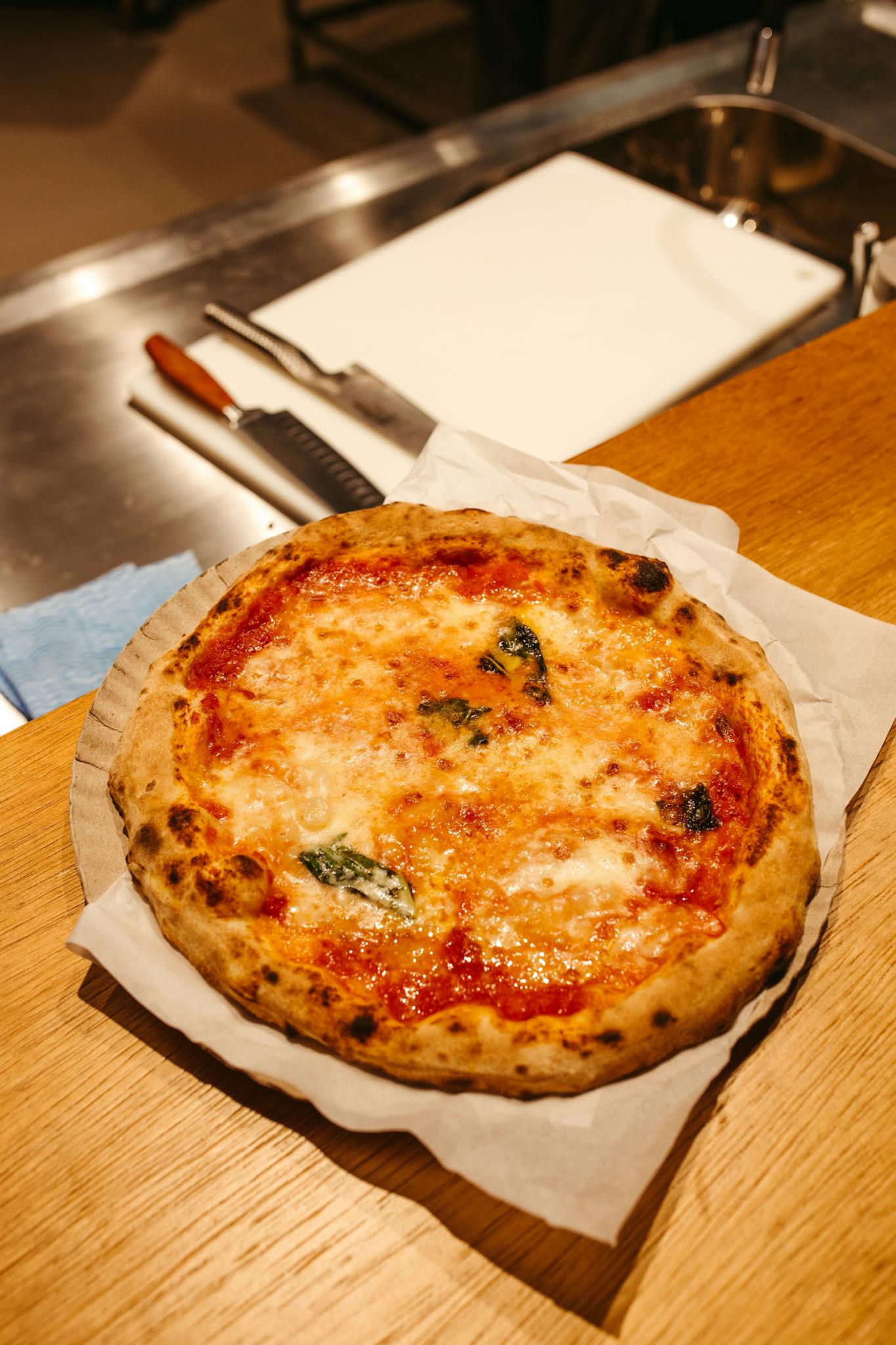 Freshly baked Margherita pizza with basil on parchment, perfect for Italian cuisine lovers.