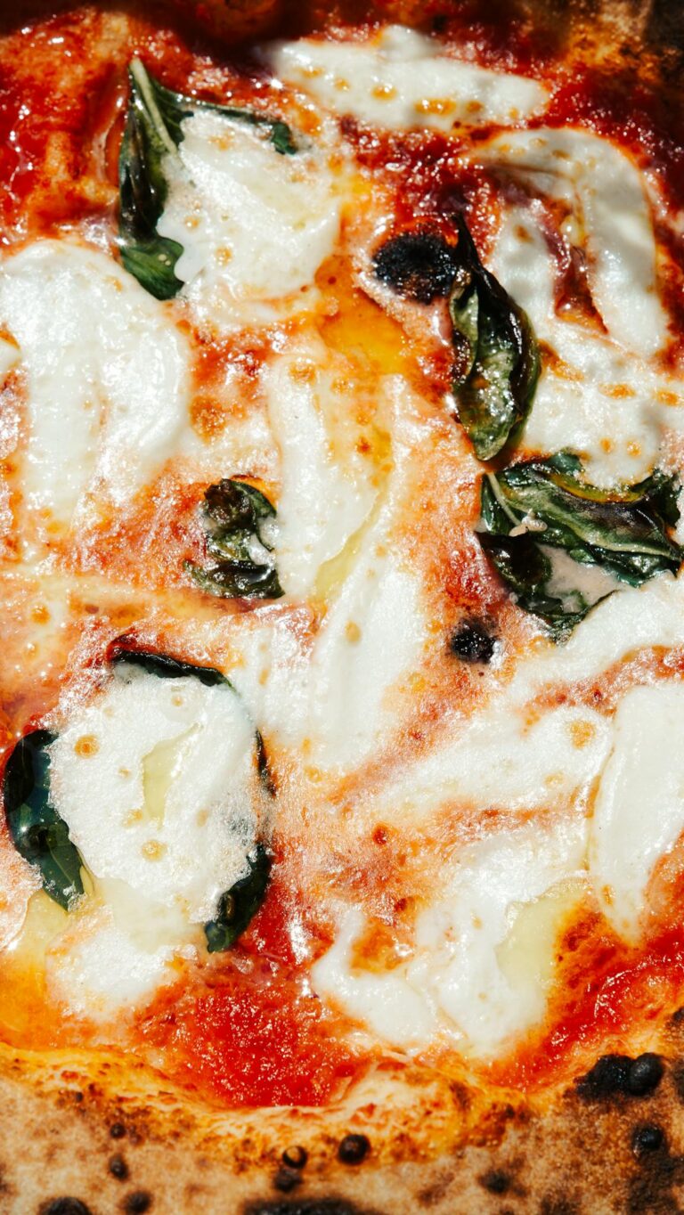 Mouth-watering Margherita Pizza with fresh basil, mozzarella, and tomato sauce.